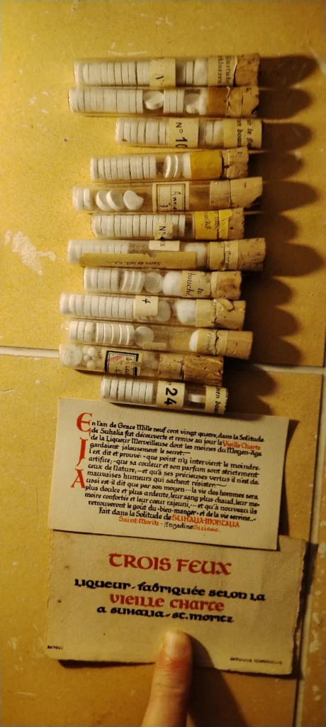 Préparations médicinales et pastilles homéopathiques fabriquées à Suhalia selon une vieille charte alchimique, avec étiquettes manuscrites.